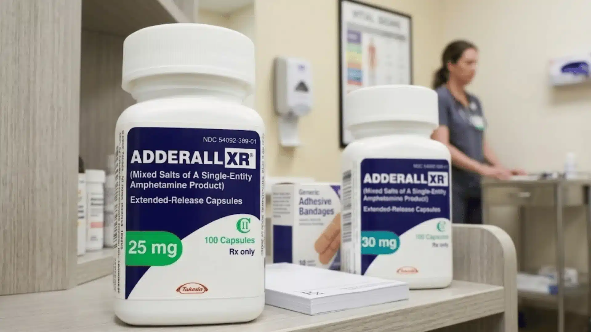 Adderall XR prescription bottles 25 mg and 30 mg on clinic counter with medical setting background