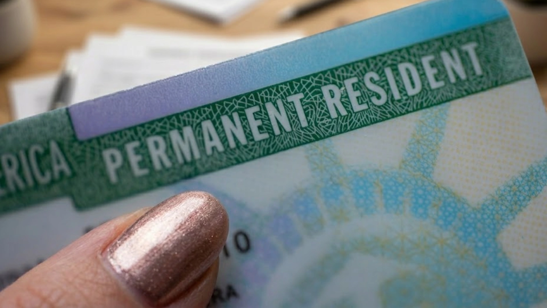 Close-up of a green card showing Permanent Resident text, highlighting official US immigration identification details