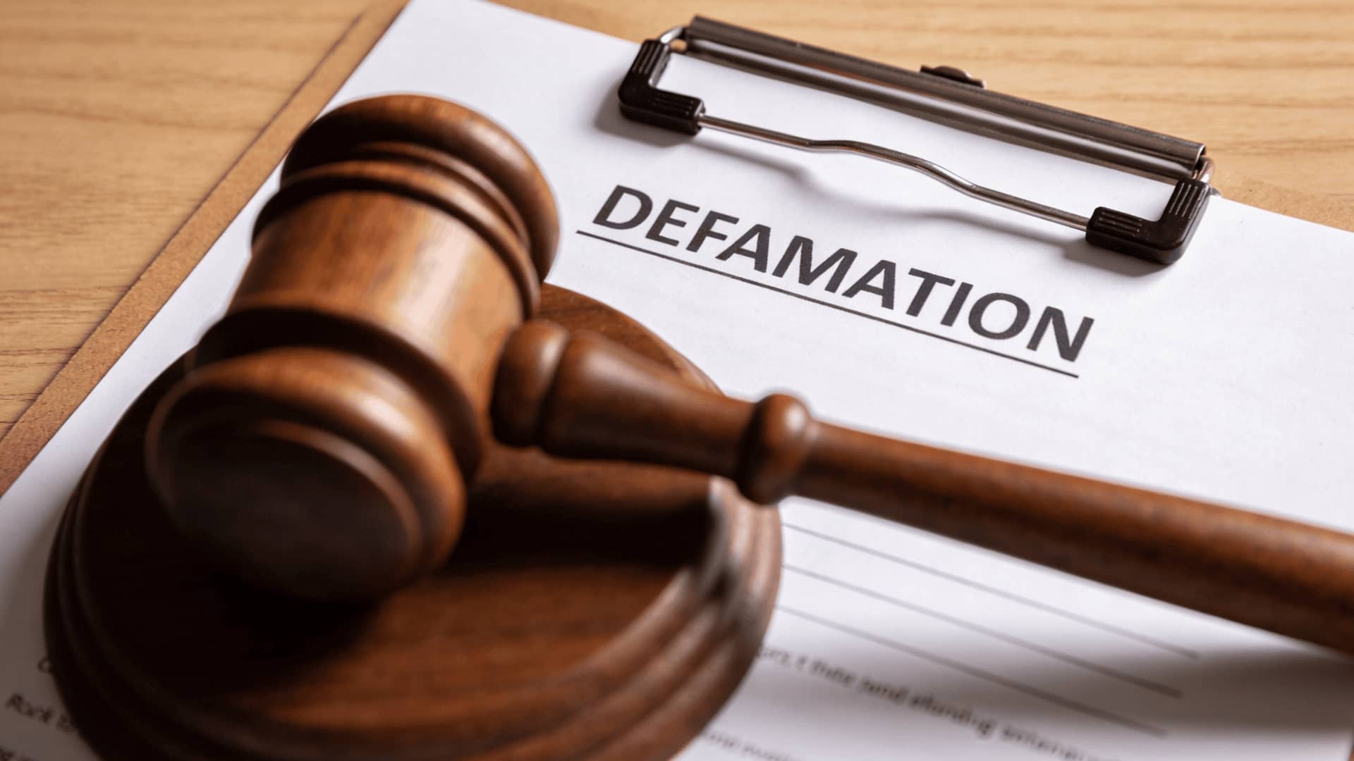 Judge’s gavel on document labeled defamation representing legal dispute concept