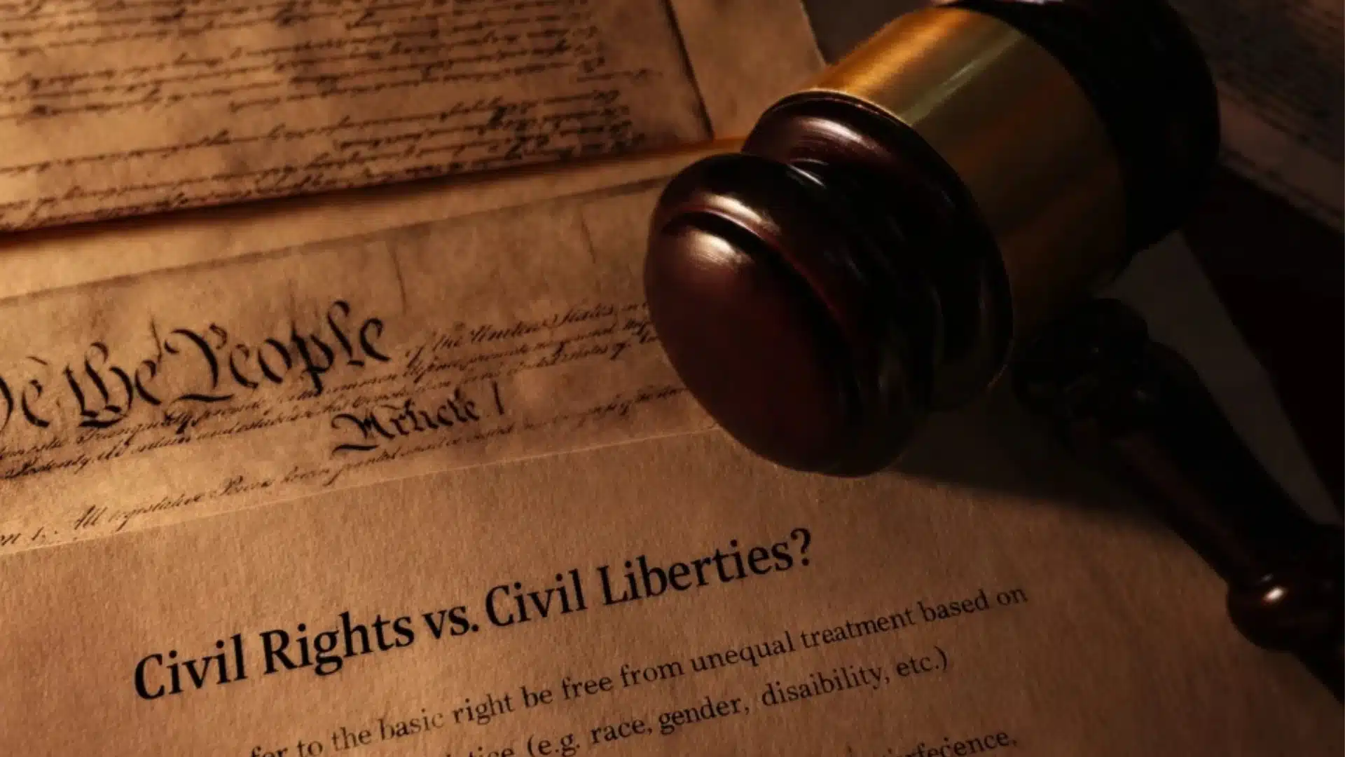 A wooden gavel rests on legal documents, including the U.S. Constitution and a paper titled _Civil Rights vs. Civil Liberties__