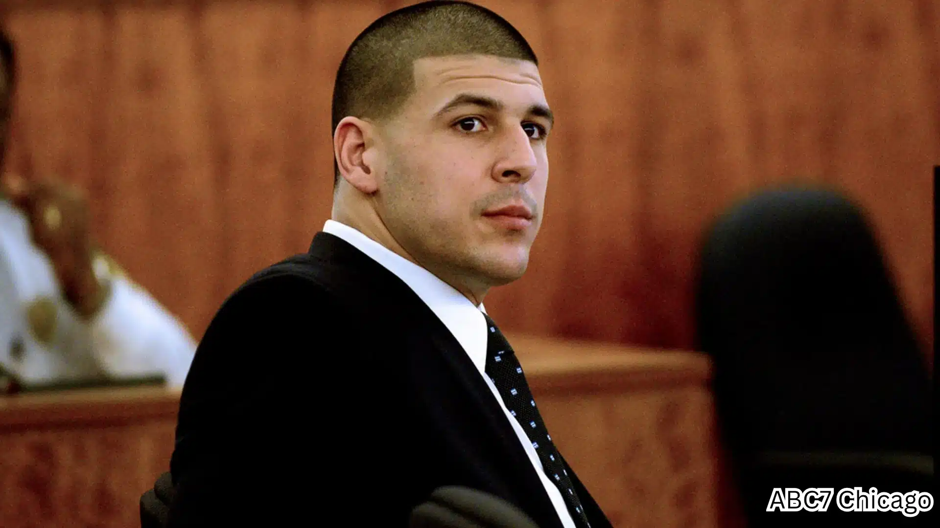 Aaron Hernandez seated in a courtroom during murder trial proceedings related to the Odin Lloyd case