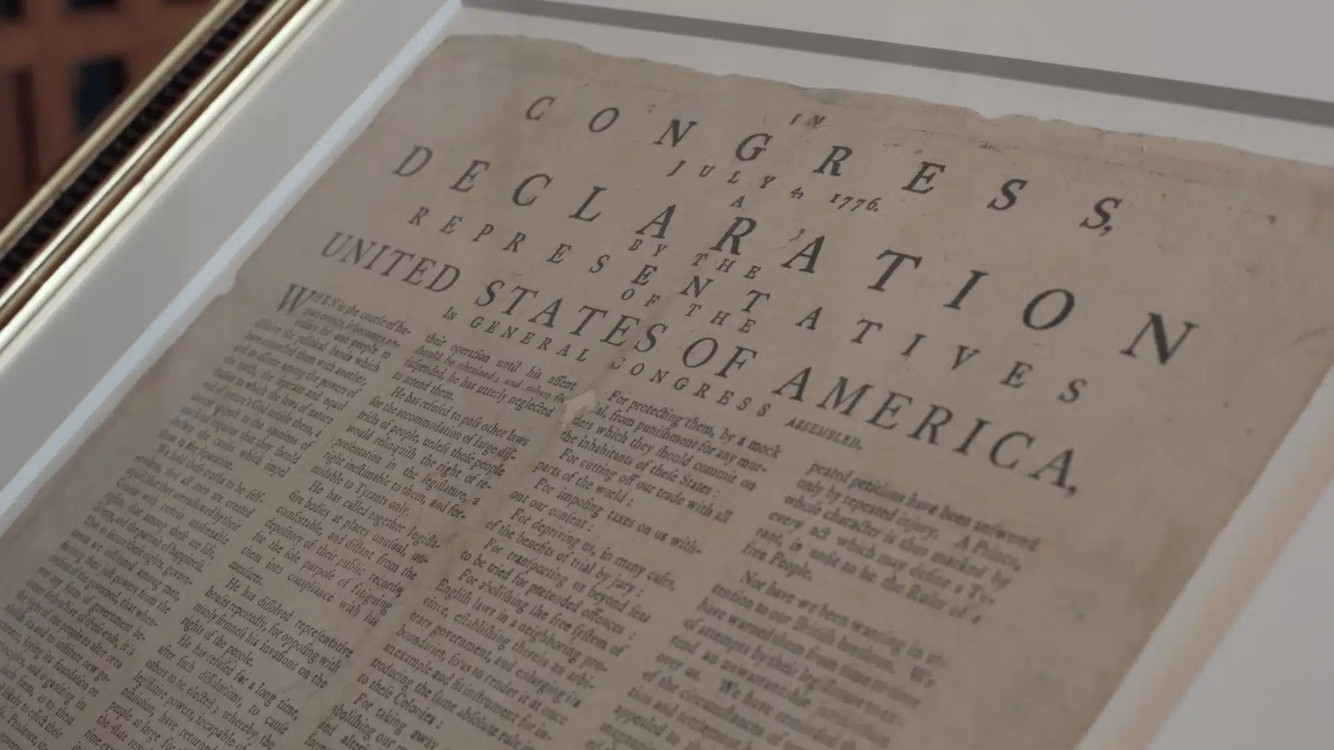Framed copy of the Declaration of Independence displayed under glass with aged paper and bold historic text