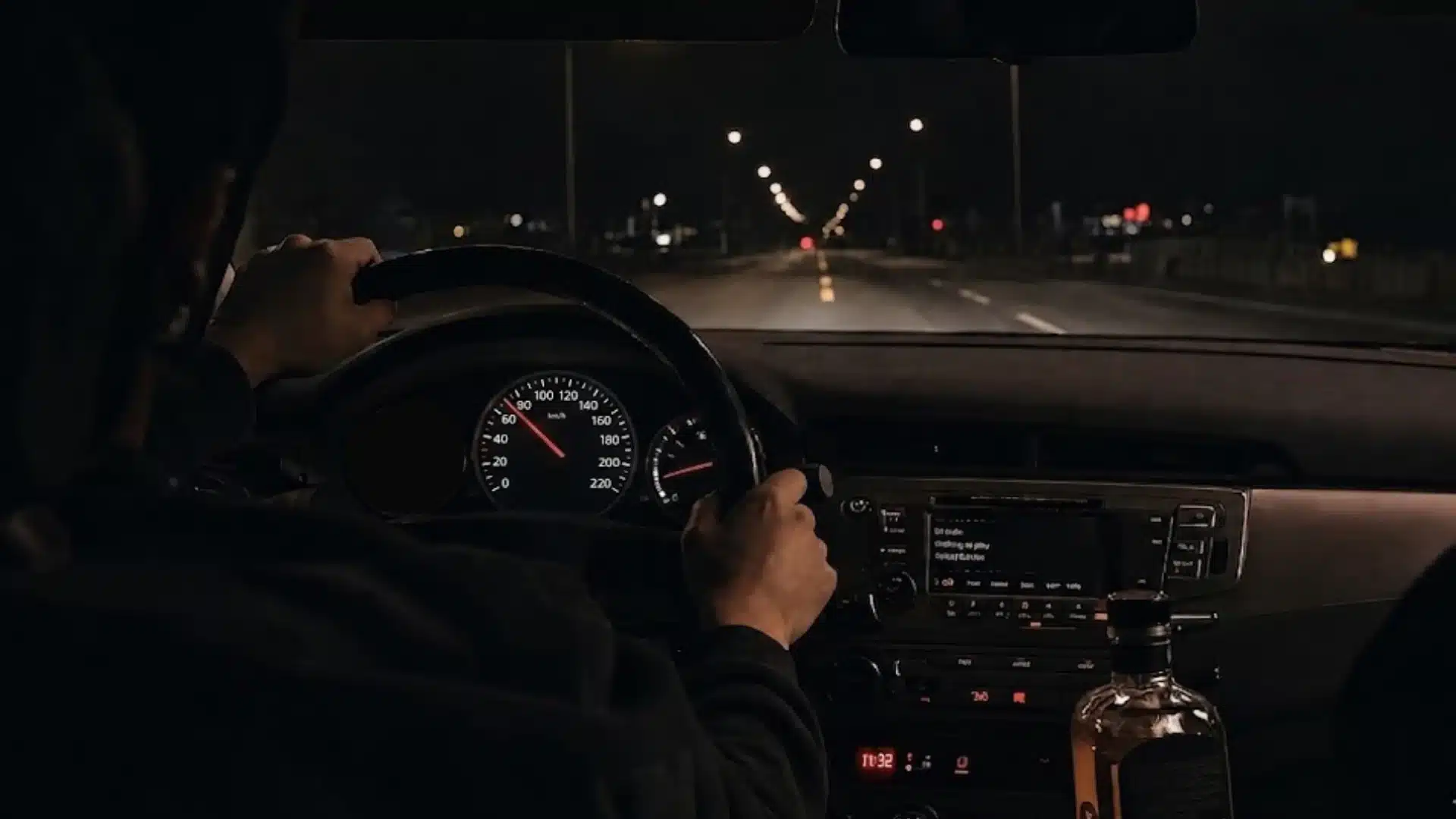 Night time drive interior with speedometer lit up and a bottle of liquor visible (1)