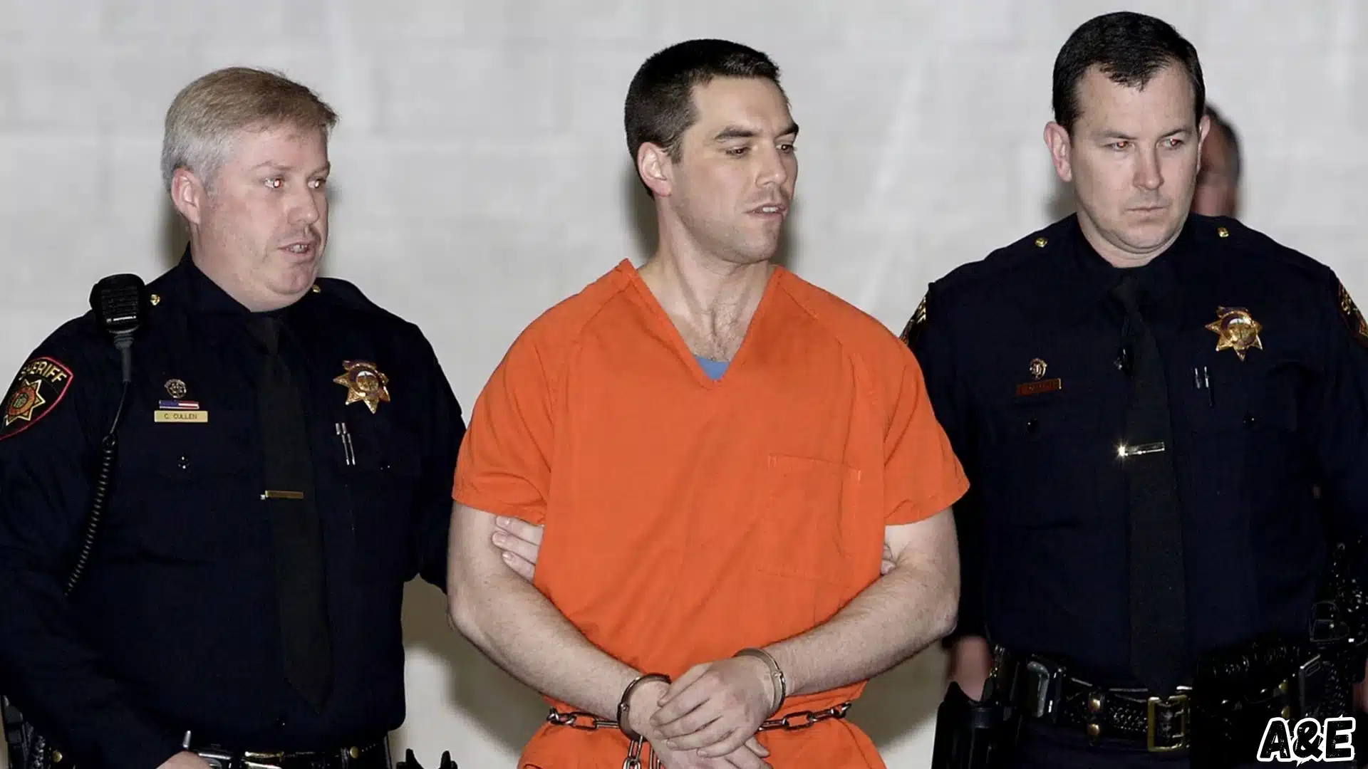 Scott Peterson in an orange prison uniform while being escorted by officers during court proceedings