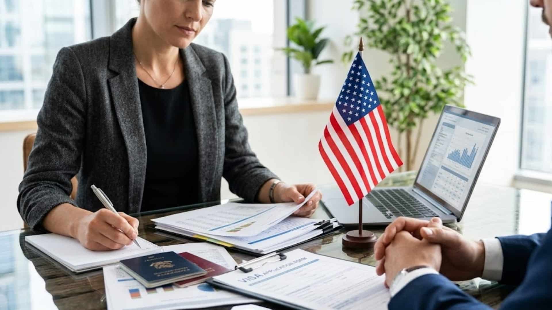 Immigration officer reviewing visa application documents during a consultation with a U.S. visa applicant at a desk