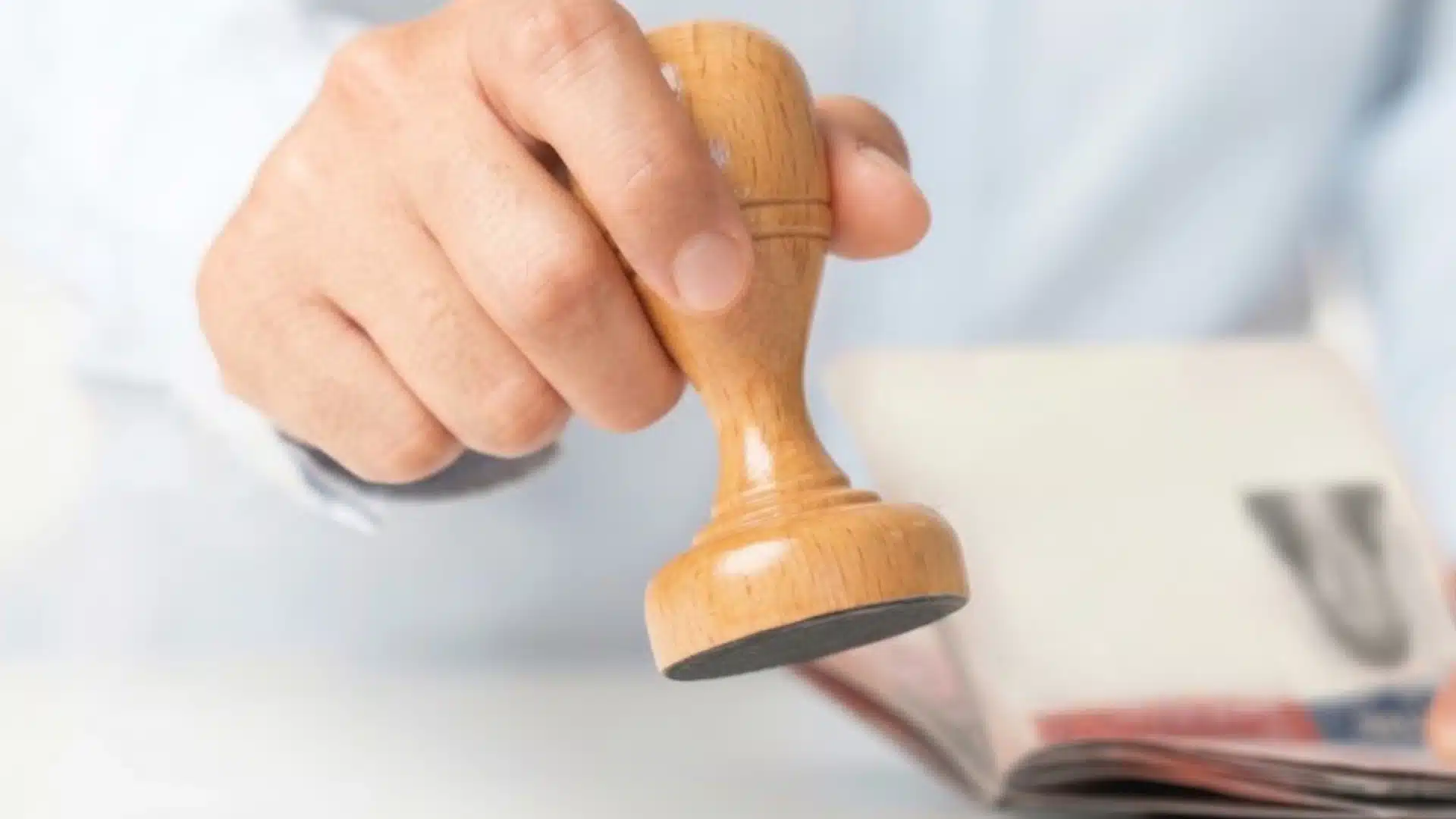 Immigration officer stamping travel document during visa approval or immigration application processing procedure