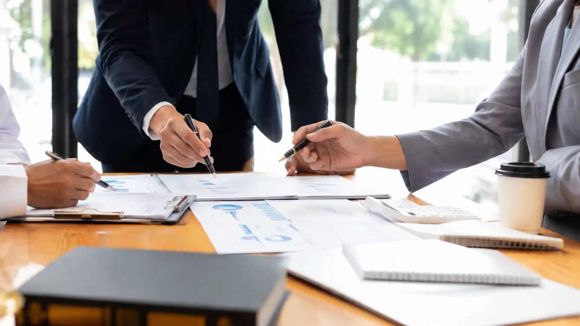 Licensed professionals review PLLC documents and financial charts in a modern office